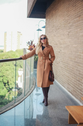 a lady in a black top and a long wool trench coat